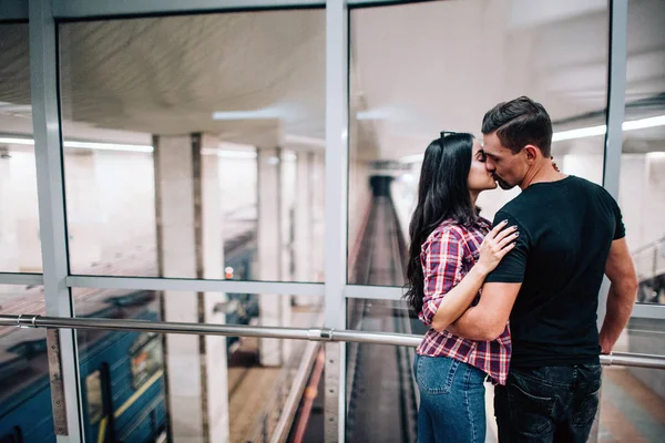 Νεαρός άντρας και γυναίκα χρησιμοποιούν υπόγεια. Ζευγάρι στο μετρό. Νεαρός άντρας και γυναίκα φιλιούνται στη μητροπολιτική. Αγκαλιαστείτε. Ιστορία αγάπης. — Φωτογραφία Αρχείου