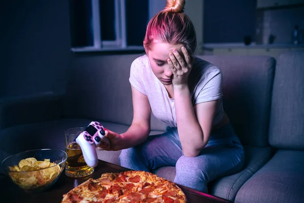 Ung kvinna spelar spel på natten. Upprörd olycklig modell titta ner. Löst spel. Håll gamepad i handen. Titta på streaming Play Alone. — Stockfoto