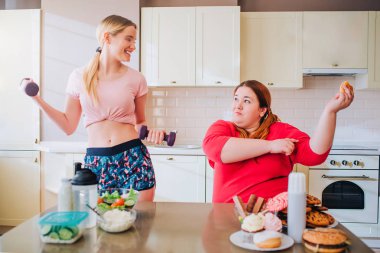 Genç sim kadın dumbbells tutan. Yağ artı boyut modeline bakıyorum. Vücut pozitif. Kilolu kadın burger ve diğer abur cubur yeme.