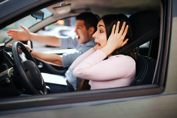 Homme instructeur auto prend examen chez la jeune femme. Des cris et des cris. Au plaisir. Femme conduire une voiture mais ne tient pas la main sur le volant. Stress et inconfort . — Photo