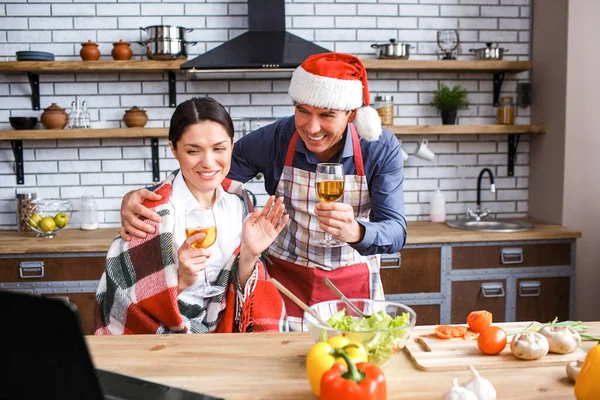 Alegre feliz hombre y mujer en la cocina celebrando la víspera de Navidad o año nuevo. Mira el portátil y agita las manos. Sonríe. Cocinar en la cocina. Humor festivo . — Foto de Stock
