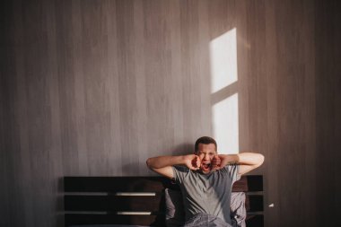 Sabahları yatağında bir adam. Geriniyor. Güne harika bir başlangıç