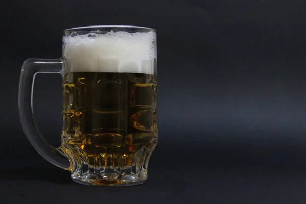 Fındıklı koyu bir arka planda bir kupa bira.