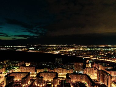 Geceleri şehre tepeden bakan, sokakları aydınlatan ve karanlık olan insansız hava aracı