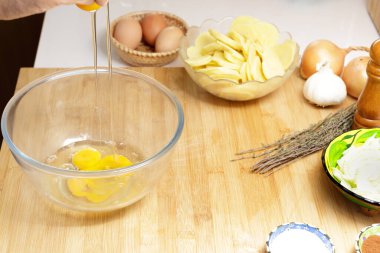 Omlet hazırlamak için mutfakta yumurta kırıyorum.