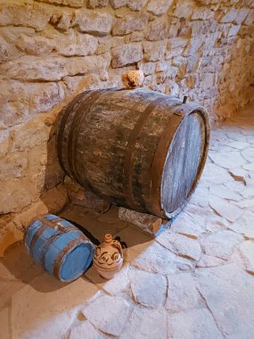 Soğuk ve nemli taş kilerde eski şarap fıçıları. Eski tarz. Doğal ışıklandırma.