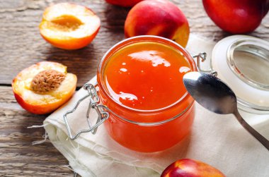 Şeftali ve nektarin ahşap bir masa üzerine taze meyve ile bir kavanoz reçel. Hasat, koruma.