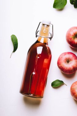 Elma sirkesi elma ve yaprakları beyaz tahta masada bir şişe. Rustik tarzı. Üstten görünüm.