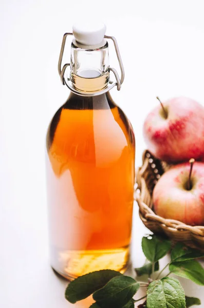 Apple vinegar in a bottle on white wooden table with apples. Rustic style. — Stock Photo, Image