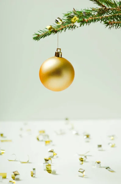 Rama espinosa del árbol de Navidad sobre un fondo claro con un árbol de Navidad y serpentinas. Minimalismo . — Foto de Stock