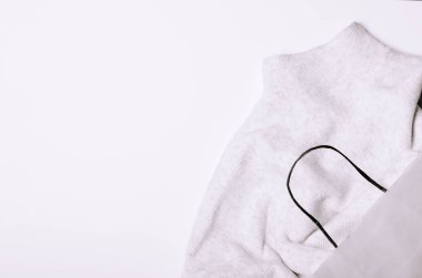 Kağıt torba deposundan beyaz bir arka plan üzerinde beyaz kazak. Alışveriş, kış için alışveriş kavramı.