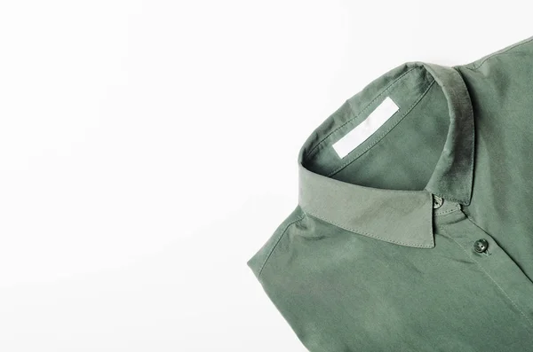 Camisa verde doblada sobre fondo blanco. Concepto moda, compras . — Foto de Stock