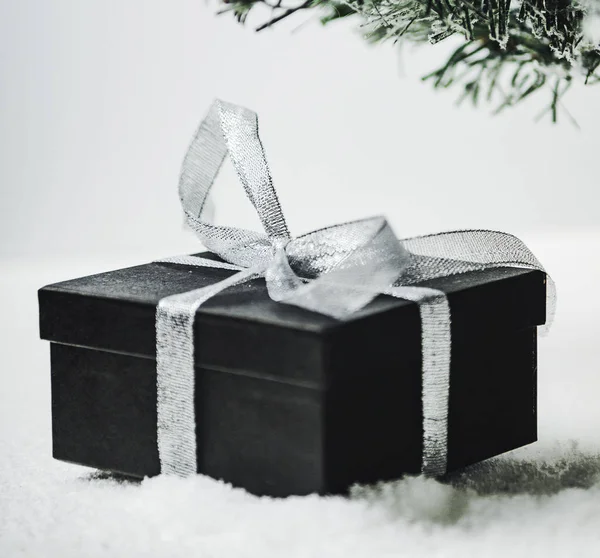 Caja de regalo con un lazo de cinta de plata debajo del abeto. Año Nuevo sorpresa de Santa Claus . — Foto de Stock