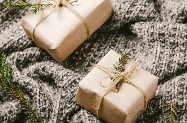Подарочные коробки на теплой вязаной серой клетчатой клетке с ветками елки. Уютный новый год . — стоковое фото