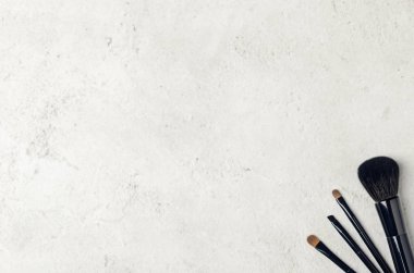 Hafif bir taş arka plan üzerinde siyah makyaj fırçaları. Makyöz için profesyonel araçlar. Düz yatıyordu, en iyi görünüm, kopya alanı.