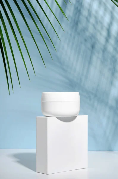 Witte Pot Crème Een Stand Een Blauwe Achtergrond Met Tropische Stockfoto