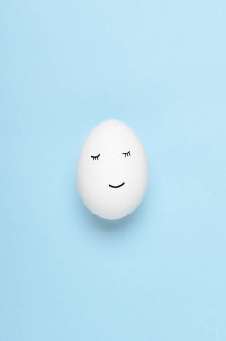 Kawaii mavi arka planda beyaz yumurtalara bakıyor. Çizgi filmler, çocuklar için dekorasyon yemekleri. Üst manzara, düz uzanma