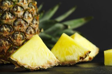 Siyah arka planda ananas ve ananas dilimleri. Lezzetli, sulu, diyet, yaz meyvesi