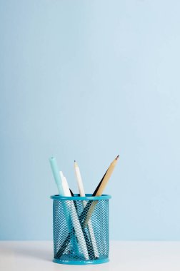 Mavi, beyaz ve siyah kalemler, mavi arka planda beyaz bir masanın üzerinde duran kalemler, ofis masası. Boşluğu kopyala