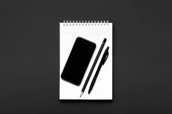 Notebook Alb Deschis Creion Negru Stilou Smartphone Fundal Negru Birou — Fotografie, imagine de stoc