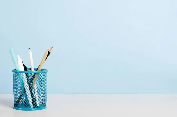Mavi, beyaz ve siyah kalemler, mavi arka planda beyaz bir masanın üzerinde duran kalemler, ofis masası. Boşluğu kopyala