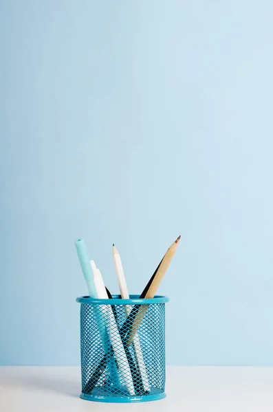 Mavi, beyaz ve siyah kalemler, mavi arka planda beyaz bir masanın üzerinde duran kalemler, ofis masası. Boşluğu kopyala