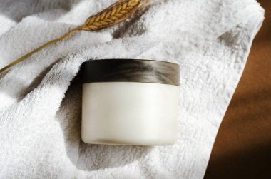 Saç maskesi, banyo havlusunda merhem kavanozu modeli. Kozmetik krem boş kap. Vücut bakım ürünleri, temizlik malzemeleri. Yüz bakımı, nemlendirici maske, saç kremi, yakın plan görüntü..
