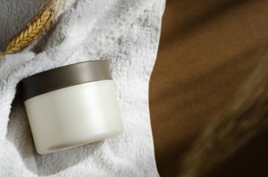 Saç maskesi, banyo havlusunda merhem kavanozu modeli. Kozmetik krem boş kap. Vücut bakım ürünleri, temizlik malzemeleri. Yüz bakımı, nemlendirici maske, saç kremi, yakın plan görüntü..