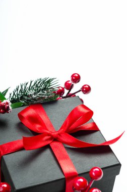 Hediye kutusu ve Holly Ilex 'in böğürtlenleri. Yeni yıl, Noel hediyesi. Telif alanı olan şenlikli bir zemin. Dekoratif unsurlu Noel kompozisyonu. Kış tatili kavramı.