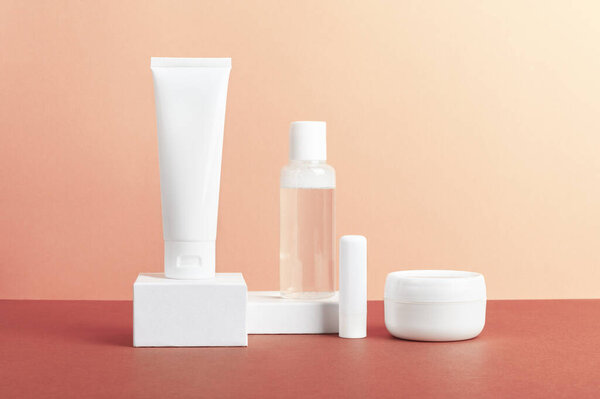 Женщины кожа продукты пустые упаковки композиция на розовом фоне. Без бренда удаления лака для ногтей, бальзам для волос или лосьон для тела банка, крем для рук. Женские макеты косметики для рекламного дизайна.