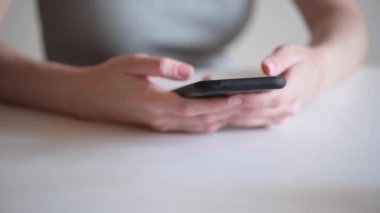 Kadın eller ellerinde bir akıllı telefon tutuyor ve ağda bir mesaj yazıyor. Freelancers 'ın merkez ofisi telefonda. Bir iş kadını evde uzaktan çalışmak için modern bir cihaz kullanır..