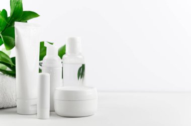 Beyaz arka planda yüz ve vücut bakımı için organik kozmetik paketleri. Krem, şampuan, losyon ve ruj arkaplanda bir kompozisyonda. Cilt, dudaklar ve saç bakımı. Mockup, boşluğu kopyala.