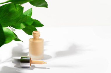 Makyaj için kozmetik ürün. Pipetli markasız sıvı fondöten krem şişesi. Yüz düzeltme kozmetiği. Çevre dostu kozmetoloji ve güzellik konsepti. Uzayı sağ tarafa kopyala.