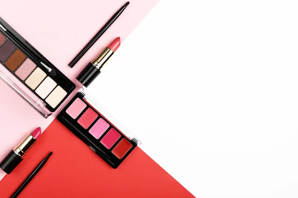 ピンク 赤の背景に製品を構成します 上記からアイシャドウパレット 口紅やブラシ 装飾的な化粧品のトップビューの背景 女性の魅力 プロの美容製品 — ストック写真