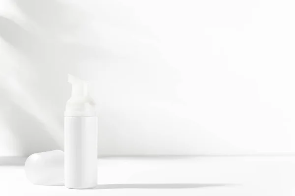 Yüz bakımı, vücut bakımı kozmetik şişesi ve şeker kutusu. Işık modelinde beyaz markasız flakon. Besleyici ya da nemlendirici köpük, losyon, krem, merhem için boş bir paket. Cilt ürünleri reklam konsepti.