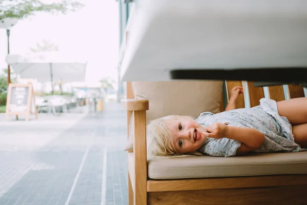 Очаровательная Маленькая Девочка Лежит Скамейке Кафе Открытом Воздухе — стоковое фото