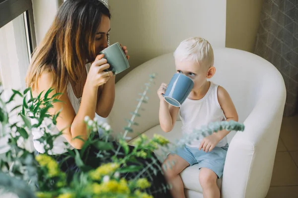 Mother Her Little Son Holding Cups Sitting Sofa — Stock Photo, Image
