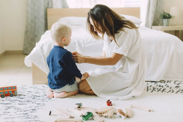 Young Beautiful Mother Buttoning Shirt Her Little Son Bedroom — Stock Photo, Image