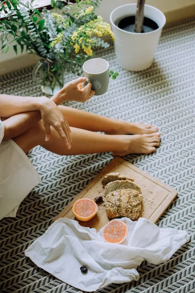 Young Woman Holding Cup Coffee Sitting Wooden Board Sliced Freshly — Stock Photo, Image