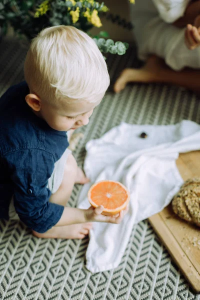 Маленький Мальчик Держит Половину Грейпфрута Смотрит — стоковое фото