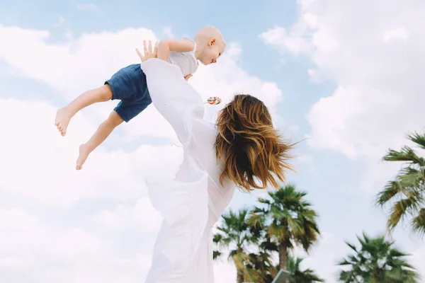 Young Mother Tossing Her Little Son Sky Beach — Stock Photo, Image