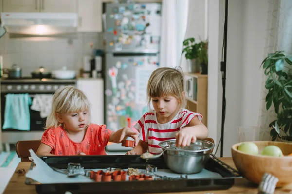 Two cute little sisters cooking at home — Stock Image Two Cute Little Sisters Cooking Home Royalty Free Stock Images
