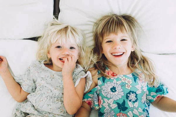 Dwie Kochające Małe Siostry Leżąc Łóżku Przytulanie Uśmiechając Się — Zdjęcie stockowe