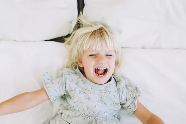 可爱的小女孩休息和微笑在床上在家里 — 图库照片