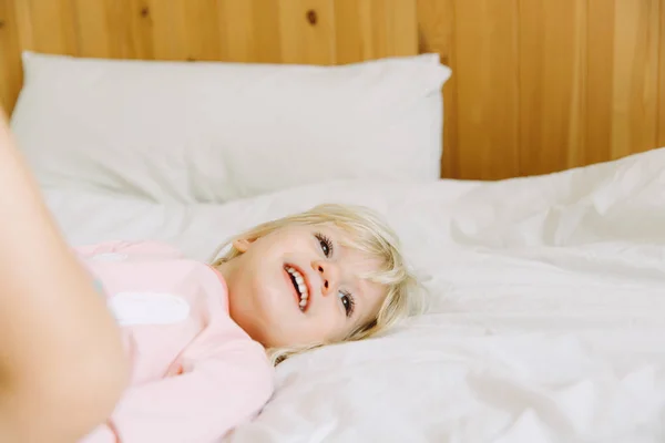 かわいい女の子休んで 自宅ベッドの上で笑顔します レジャー — ストック写真