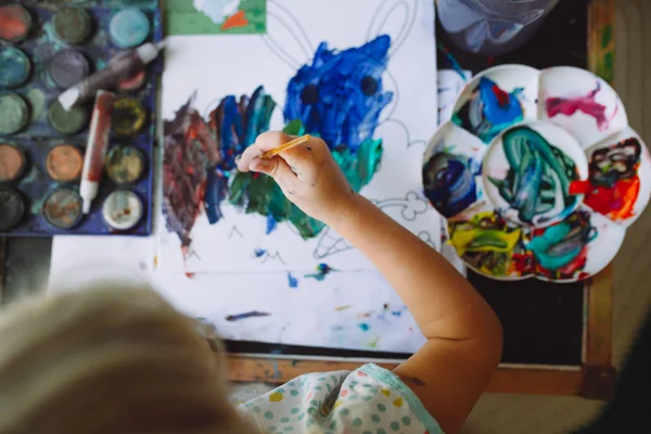 Adorable little girl painting at home