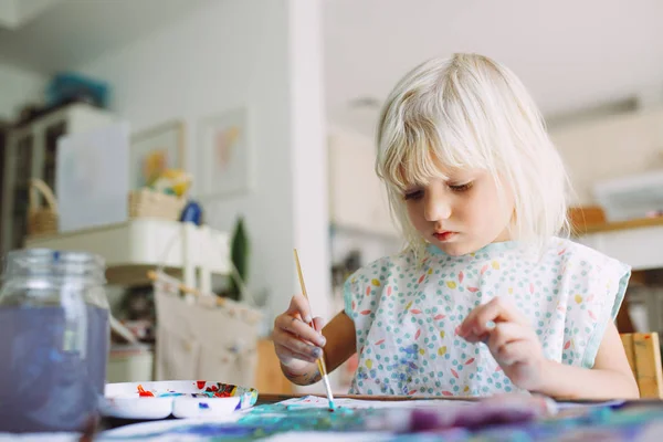 Adorable little girl painting at home