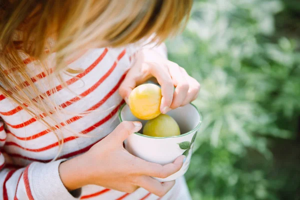 Küçük kız elinde bir fincan sarı kiraz eriği tutuyor. — Stok fotoğraf