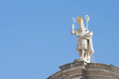Hırvatistan 'ın Dubrovnik kentindeki Aziz Blaise Kilisesi' nin tepesindeki heykel, güneşli bir günde elinin üzerinde bir ay var..