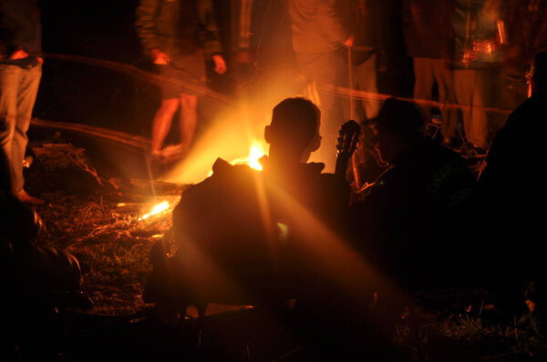 Старе Яблонки, Варминско - Мазурское воеводство / Польша - 05.14.2016: Двое людей разговаривают у костра ночью.